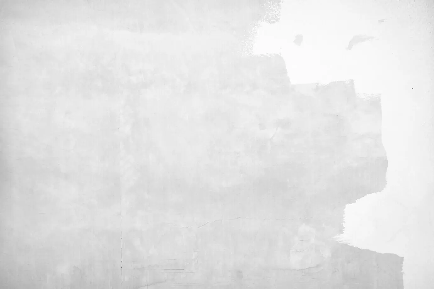 Graue Farbe vor dem Hintergrund einer rissigen Betonwand.